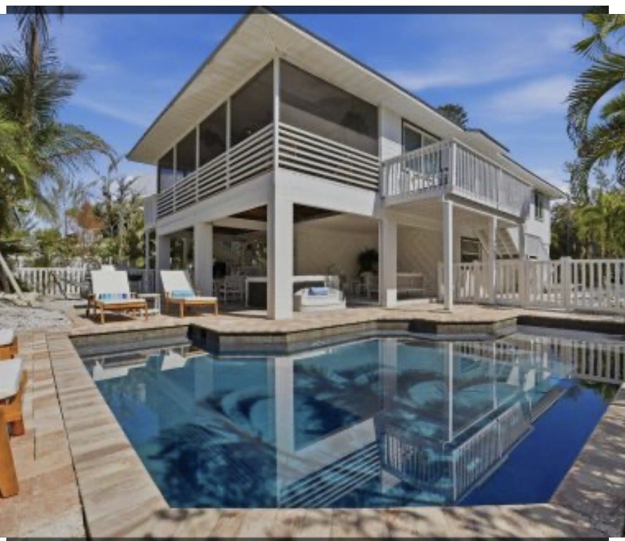 Elevated coastal home with screened porch, covered lounge deck and a pool