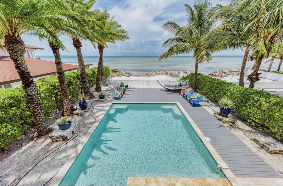 Oceanfront rental with a long private pool, palm trees and direct beach access